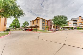 Parking area with covered carports and apartment buildings